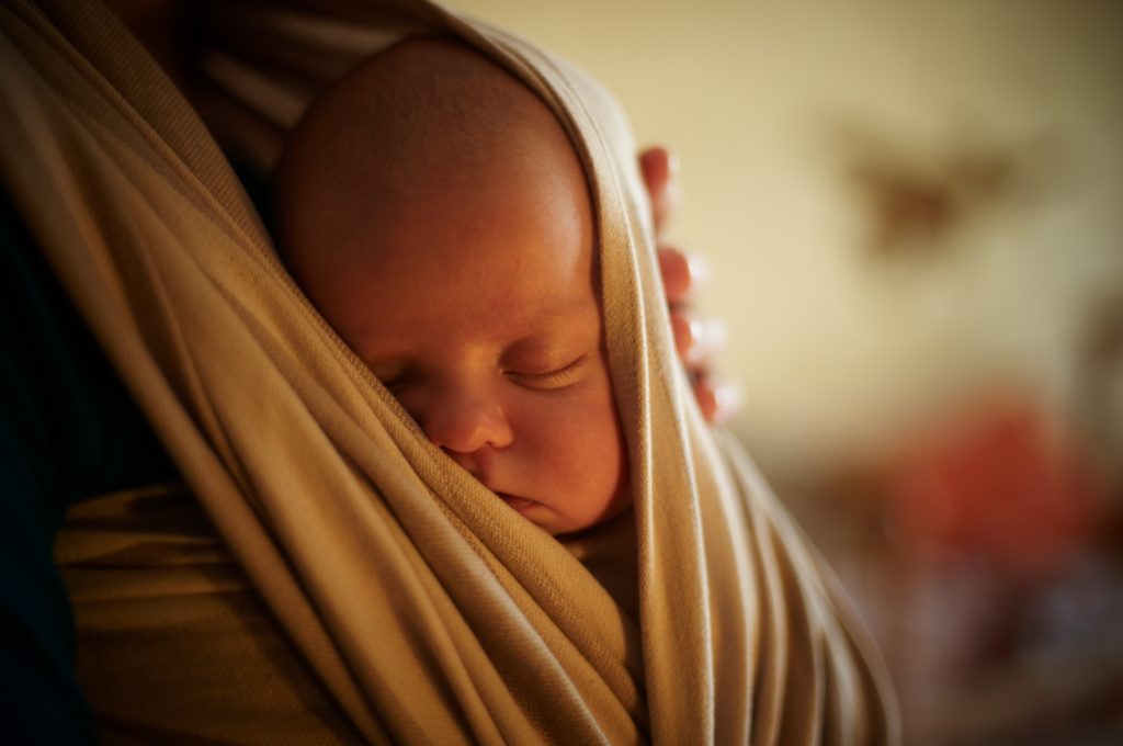 newborn baby being worn in a wrap